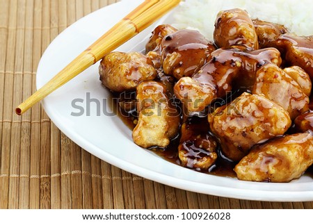 General Tso\'s Chicken served with white rice. Shallow depth of field.