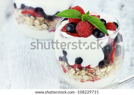 Delicious and healthy yogurt parfait made with Greek yogurt, fresh berries and mint. Extreme shallow depth of field.