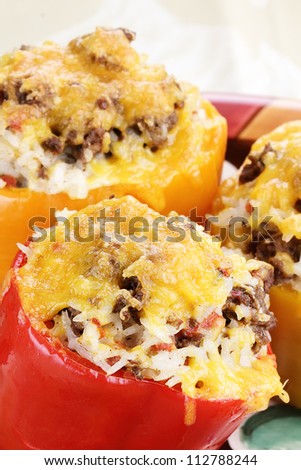 Three baked bell  stuffed peppers with beef, rice, vegetables and cheese. Shallow depth of field.