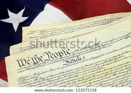 American Constitution lying over top of the US flag.