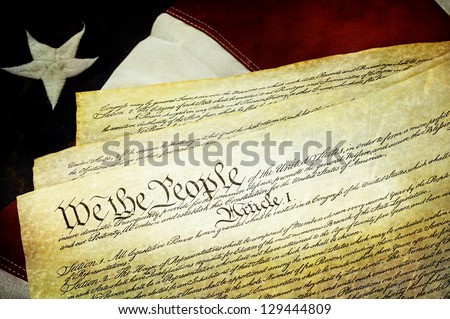 Textured American Constitution lying over top of the US flag.