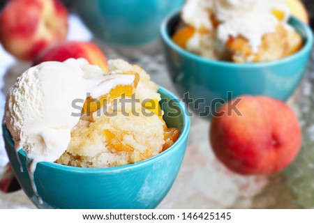 Fresh peach cobbler served with vanilla ice cream.