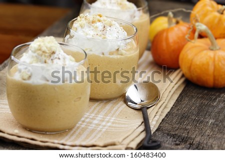 Three fresh Pumpkin Smoothies against a rustic background with shallow depth of field. Selective focus on center smoothie.