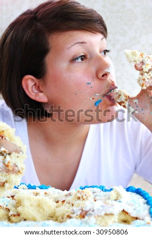Young girl eating cake by the handful.