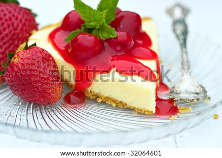 Luscious cheese cake with cherry sauce, mint and fresh strawberries.