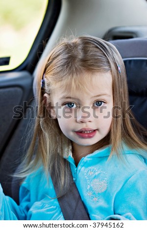 Little girl in a car seat looking at the viewer.