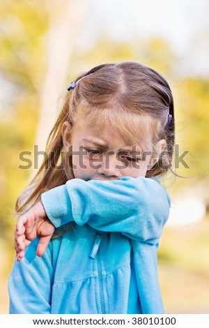 stock photo : Little girl demonstrates coughing or sneezing into her sleeve stock photo : Little girl demonstrates coughing or sneezing into her sleeve
