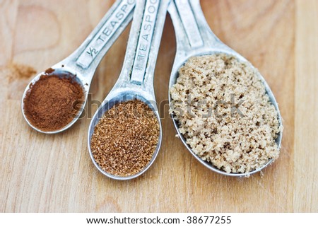 Measuring spoons filled with pumpkin spice, brown sugar and cinnamon.