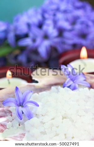Relaxing and beautiful spa still life with candles, purple flowers and bath salts.