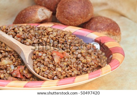 Delicious healthy lentils prepared with fresh diced tomatoes and onions. Shallow DOF with selective focus on spoonful of lentils.