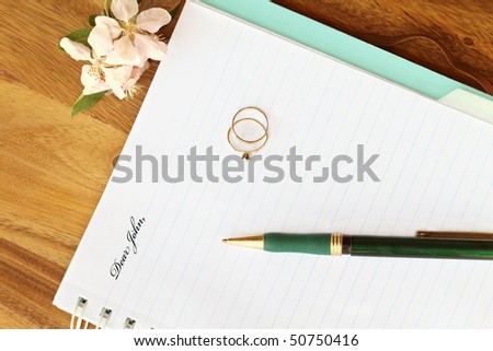 stock photo Dear John letter with woman's engagement and wedding rings