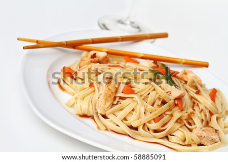Plate of delicious healthy Asian Chicken Pasta with grilled chicken and carrots. Extreme shallow DOF with selective focus on front on noodles.