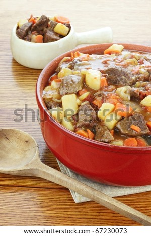 Crock pot full of fresh made roast beef with large chunks of beef, potatoes and carrots.