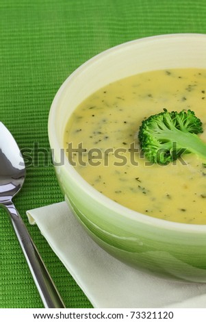 Bowl of cream of broccoli soup with a sliced broccoli garnish.