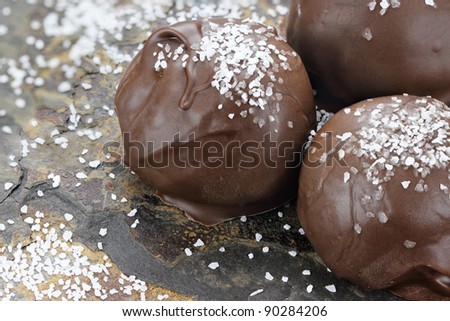 Chocolate truffle candies with sea salt. Shallow depth of field with selective focus on first truffle.