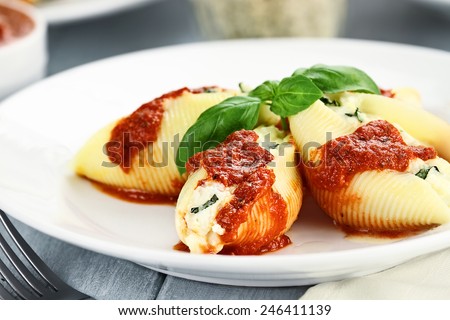 Conchigliei pasta stuffed with a ricotta cheese, mozzarella and basil leaves with extreme shallow depth of field.