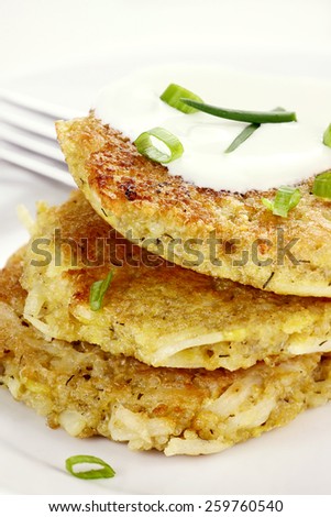 Savory Quinoa and potato pancakes with sour cream and chives. Shallow depth of field.