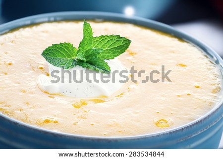 Chilled peach soup with fresh vanilla flavored sour cream. Extreme shallow depth of field with selective on bowl in foreground.