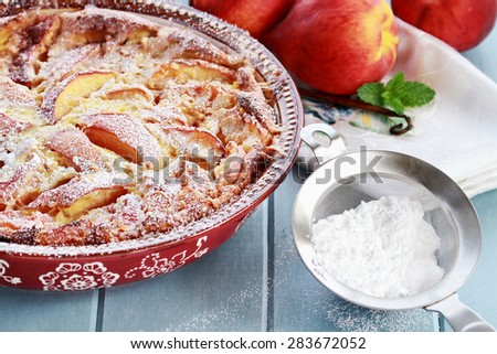 Freshly baked Peach Clafouti with powered sugar. Extreme shallow depth of field with selective center of dish.