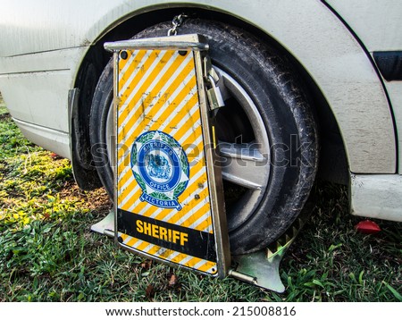 MELBOURNE, AUSTRALIA - May 8, 2014: a car wheel-clamped by the Victorian Sheriff\'s Office.  The Sheriff takes action against people who do not comply with debt-related court orders.