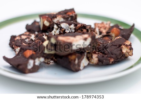 Homemade Rocky road chocolate on white plate with green trim on white background