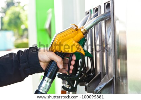 Man holding a gasoline nozzle in his hand