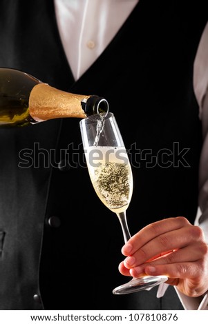 Waiter pouring champagne in a flute