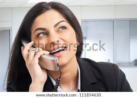 Portrait of a beautiful secretary talking on the phone