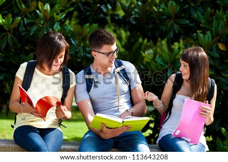 Three students on a bench in the park