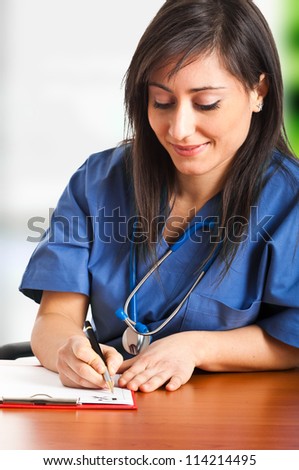 Nurse writing a medical recipe on her desk