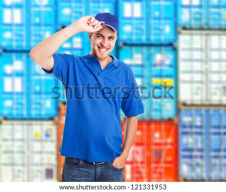 Portrait of a smiling worker in front of a stack of containers