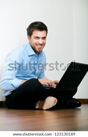 Young man sitting on the floor with his laptop