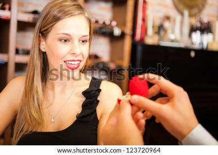 Man proposing marriage to a surprised woman