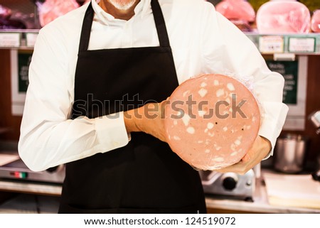 Shopkeeper showing bologna in an italian grocery store