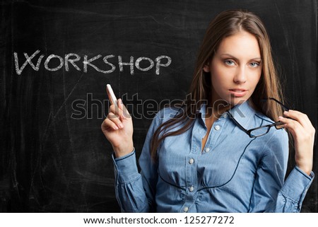 Beautiful woman writing workshop on a blackboard