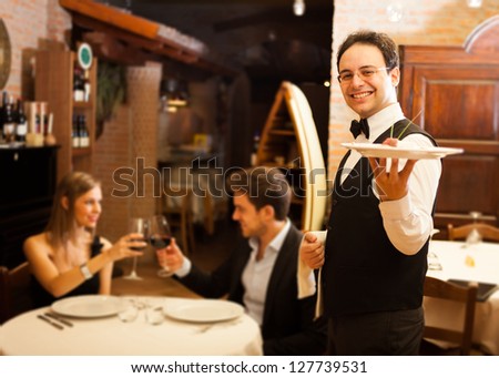 Waiter serving dinner to a couple in a restaurant