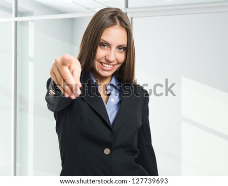 Young woman pointing at you
