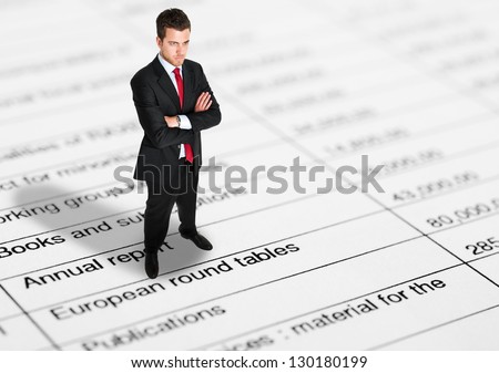 Mini businessman full length portrait on a financial paper