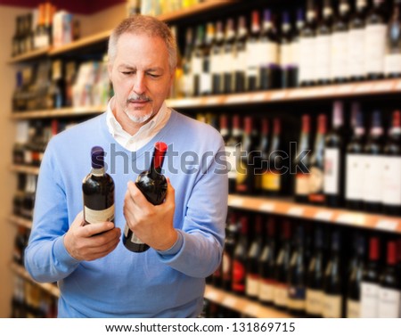 Man In A Supermarket Choosing The Right Wine