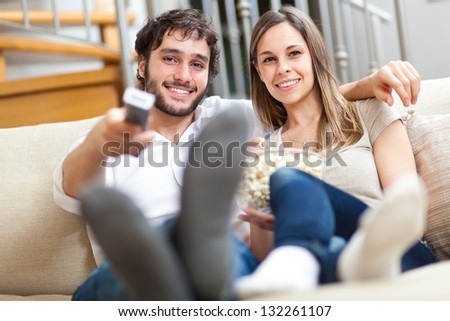 Young couple watching tv on a sofa