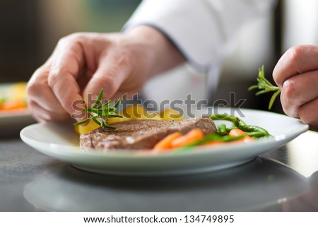 Chef Decorating A Dish In Restaurant Kitchen
