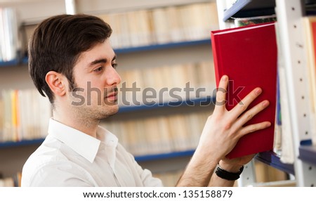 Portrait of a student taking a book from a bookshelf