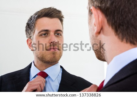Portrait of a businessman looking at himself in the mirror