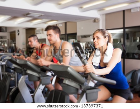 Happy People Doing Indoor Biking In A Fitness Club