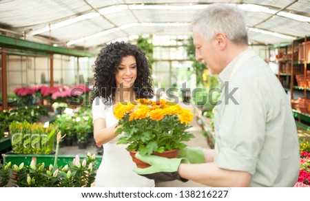 Portrait of a greenhouse worker talking to a customer