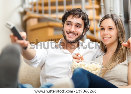 Young Couple Watching Tv On A Sofa