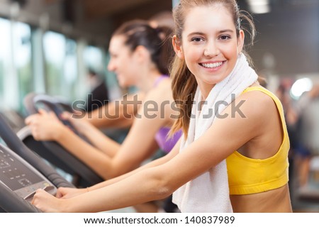 Happy people doing indoor biking in a fitness club