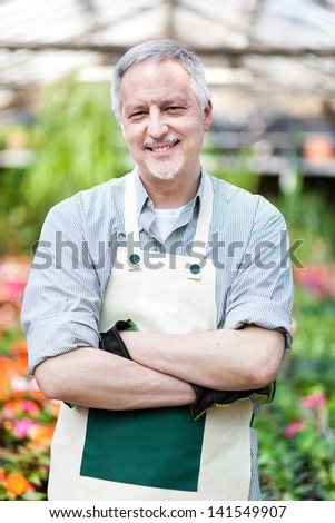 Handsome mature gardener portrait in a greenhouse