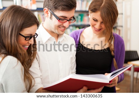 Group of people reading a book in a library