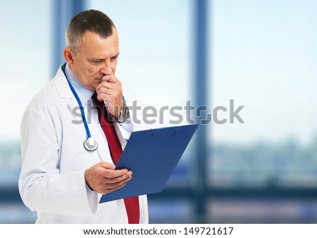 Senior doctor reading a case history